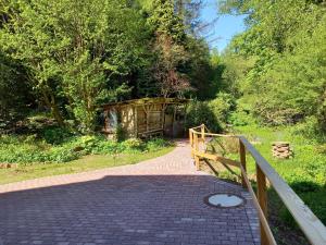 a brick walkway with a wooden fence and trees at Alte Mühle in Holzminden