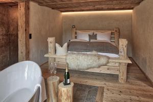 1 dormitorio con 1 cama y 1 botella de vino en Lass Zeit am Lech, en Bach
