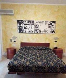 a bedroom with a bed with a cartoon on the wall at Hotel Villa Fiorita in Milano Marittima