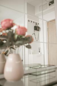 una mesa de cristal con un jarrón con flores y una cámara en SunsetView Apartment, en Oradea