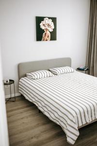 a bedroom with a bed with a striped blanket at SunsetView Apartment in Oradea