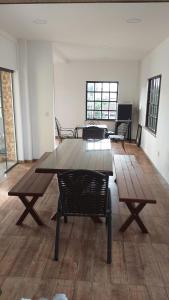 une chambre vide avec une table et des chaises en bois dans l'établissement Condomínio Pousada Amarela 100 metros da Praia, à Iguaba Grande