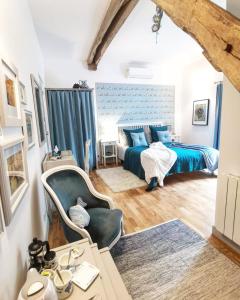 a bedroom with a bed and a desk and a table at La Maison Verte in Siorac-de-Ribérac