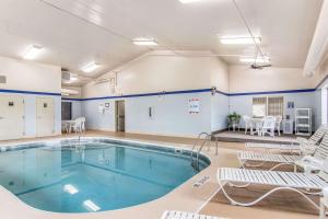 a swimming pool in a room with chairs and a table at Sleep Inn Austintown - Youngstown, West in Austintown