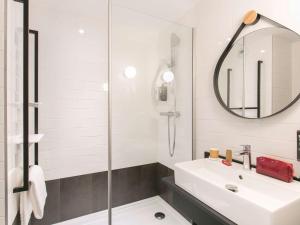 a white bathroom with a sink and a mirror at ibis Avignon Sud in Avignon