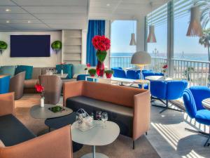 a living room filled with furniture and tables at Mercure Nice Promenade Des Anglais in Nice