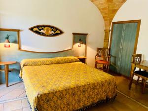 
a hotel room with a bed and a desk at Casale Gregoriano in San Gimignano
