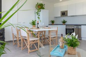 a kitchen with a table with chairs and wine bottles at Apartment Jedy Balear By homevillas360 in Son Serra de Marina +24 photos