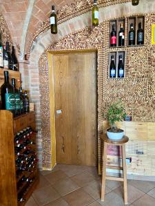 
a room with a wooden table and shelves filled with wine bottles at Casale Gregoriano in San Gimignano

