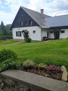 帕瑟基納利澤羅的住宿－U Tomíčků，一间白色的房子,有黑色的屋顶和院子