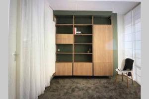 a room with a chair and a book shelf at Large and cosy house on the water: free Parking in Amsterdam