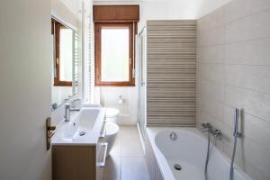 ein Badezimmer mit einer Badewanne, einem Waschbecken und einer Badewanne in der Unterkunft Appartamento Calmo 1SX in Lido di Venezia
