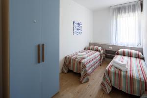 ein kleines Zimmer mit 2 Betten und einem Fenster in der Unterkunft Appartamento Calmo 1SX in Lido di Venezia