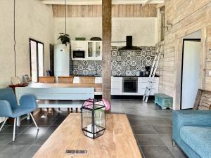 a living room with a table and a kitchen at La Belle Petite Ferme Rosiers de Julliac 19350 in Les Bos +75 photos