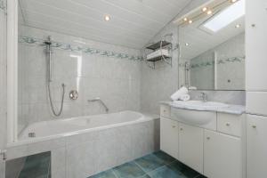 a white bathroom with a tub and a sink at Landhaus Kristall in Leutasch +22 photos