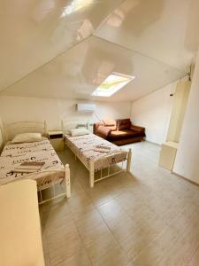 a attic room with two beds and a couch at Апартаменты люкс in Adler