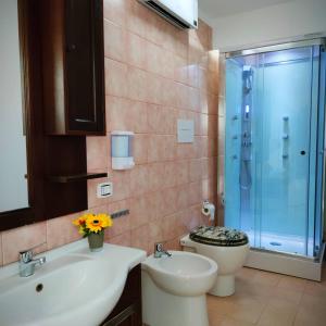 y baño con aseo, lavabo y ducha. en Room Rome, en Roccella Ionica