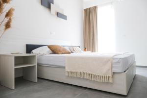 a white bedroom with a bed and a table at Le Dimore del Borgo - Room & Breakfast in Campomarino