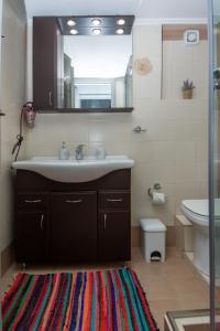 a bathroom with a sink and a mirror and a rug at Villa Bella Gonia in Gonia