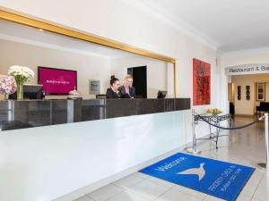 two people sitting at a reception desk in a lobby at Mercure Wagga Wagga in Wagga Wagga