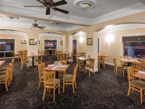 a restaurant with tables and chairs and a ceiling at Mercure Wagga Wagga in Wagga Wagga
