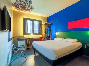 a bedroom with a bed and a desk in it at ibis Styles SP Faria Lima in Sao Paulo