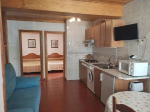 a kitchen with a sink and a stove top oven at Casa Rural López Ordesa in Frajén