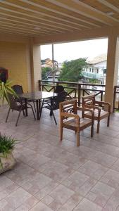 un patio con bancos, mesa, mesa y sillas en Condomínio Pousada Amarela 100 metros da Praia, en Iguaba Grande
