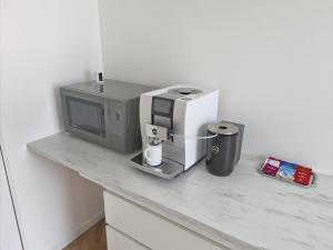 a kitchen counter with a tv and a coffee maker at Snooze in Ostend