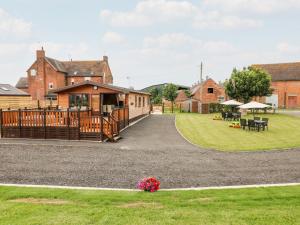 a house with a deck and a yard with tables at River Dove Lodge in Derby