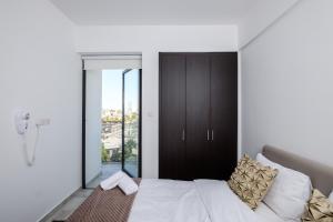 a bedroom with a bed with white sheets and gold pillows at Solaar Apartments st Lazarous in Larnaca