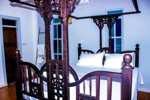 1 dormitorio con cama con dosel y sábanas blancas en Nungwi Roses, en Nungwi
