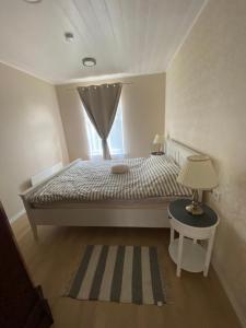a bedroom with a bed with a window and a table at Tamula apartament in Võru