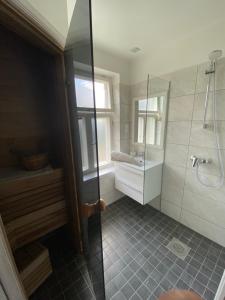 La salle de bains est pourvue d'une douche et d'un lavabo. dans l'établissement Tamula apartament, à Võru