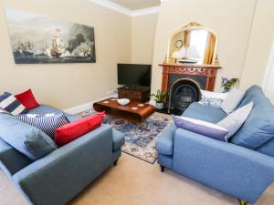 a living room with two blue couches and a tv at Regent House in Scarborough