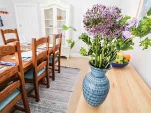 un jarrón azul con flores púrpuras sentado en una mesa en Regent House en Scarborough