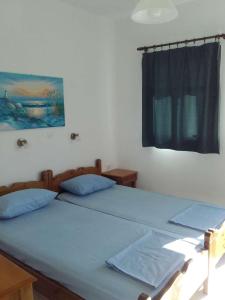 two twin beds in a bedroom with a window at Nikos Taverna and Apartments in Lefkos Karpathou