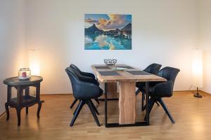 a dining room table with chairs and a painting on the wall at Ferienwohnung im Eisenbergweg in Bad Mergentheim