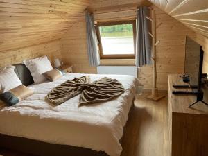 een slaapkamer met een bed met een deken erop bij La Petite Maison au bord de l'eau in Hastière-par-delà