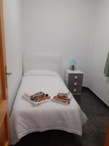 uma cama branca com duas toalhas em cima em CASA LALI em Alojera