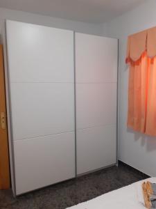 um armário com dois armários brancos com roupa laranja em CASA LALI em Alojera