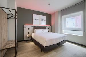 a bedroom with a bed and a ladder and a window at Hotel Bed4U Bilbao in Bilbao