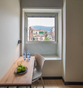 a table with a plate of apples and a window at Hotel Bed4U Bilbao in Bilbao