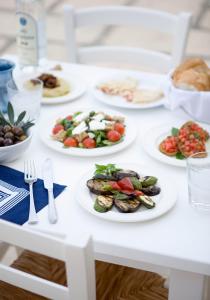 a white table with plates of food on it at Sandy Beach Hotel & Spa - ex Sentido in Larnaca