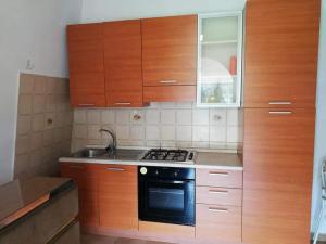 a kitchen with wooden cabinets and a black stove top oven at L' Agrumeto in Palmi