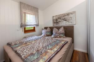 ein Schlafzimmer mit einem Bett mit einer Bettdecke und einem Fenster in der Unterkunft Ferienwohnung - Nähe Kaiserslautern in Trippstadt