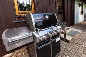 a barbecue grill with a stove on a sidewalk at Ferienwohnung - Nähe Kaiserslautern in Trippstadt