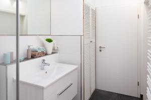 a white bathroom with a sink and a shower at Ferienwohnung - Nähe Kaiserslautern in Trippstadt +28 photos