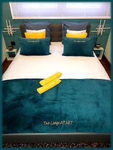 um quarto com uma cama grande e almofadas amarelas em The Lodge A'PART em Néewiller-près-Lauterbourg