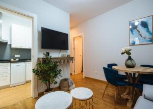 een woonkamer met een tafel en een keuken bij Feijóo Suite Apartment in Sevilla